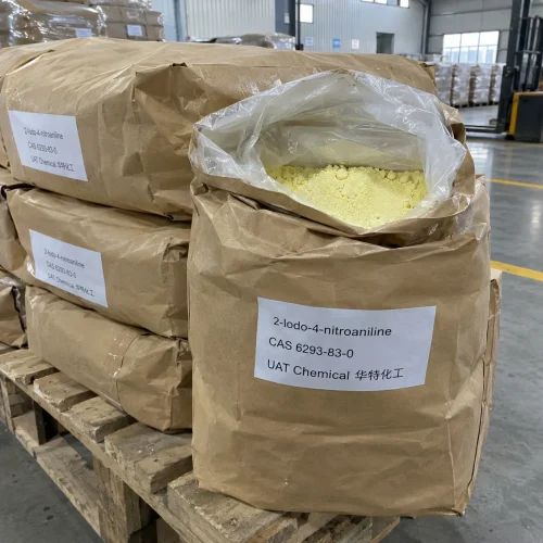 Open brown paper bag showing yellow 2-Iodo-4-nitroaniline powder CAS 6293-83-0 in an inner plastic liner, stacked with sealed bags on a wooden pallet in a warehouse.