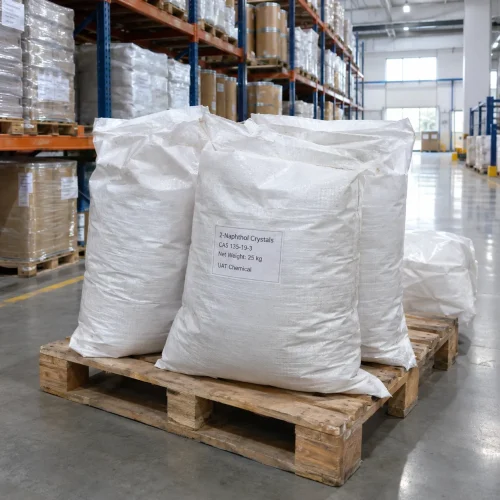 Three white woven bags of 2-Naphthol Crystals CAS 135-19-3 with 25 kg net weight stacked on a wooden pallet in a warehouse.