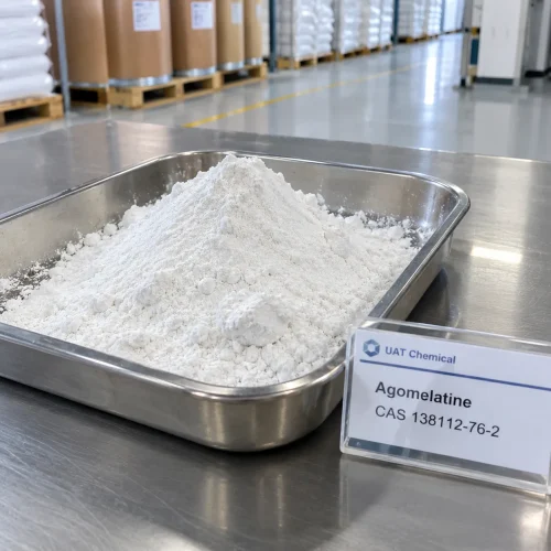 Agomelatine (CAS 138112-76-2) white powder pile in a stainless steel tray with a UAT Chemical sign card beside it