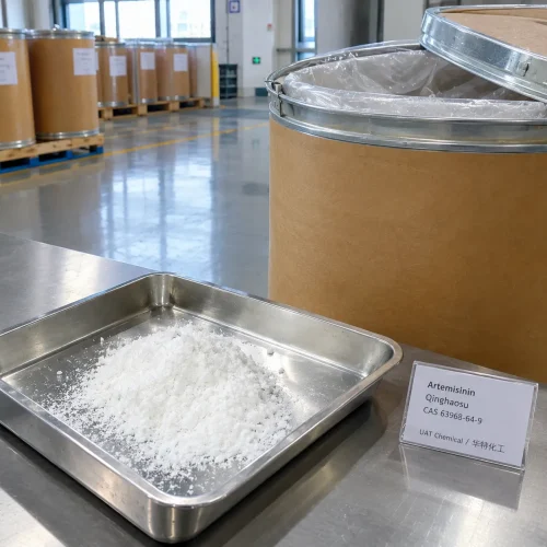 Artemisinin (Qinghaosu, CAS 63968-64-9) white crystalline powder in a stainless steel tray with a sign card