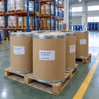 brassylic-acid-cas-505-52-2-fiber-drums Kraft fiber drums of brassylic acid (CAS 505-52-2) with steel locking rims labeled UAT Chemical on pallets in a warehouse