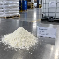 calcium-iodate-cas-7789-80-2-white-powder-sample Pile of white Calcium Iodate powder CAS 7789-80-2 on a metal table with a product label in a warehouse with bagged stock and IBC tanks behind.