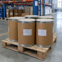 Five 25kg fiber drums of Calcium Phytate CAS 3615-82-5 on a wooden pallet in a warehouse storage area.