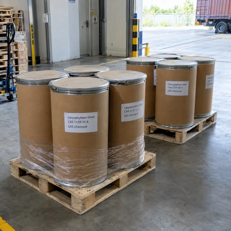 Kraft fiber drums labeled Caryophyllene Oxide (CAS 1139-30-6) shrink-wrapped on wooden pallets at a loading dock