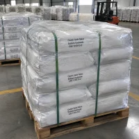 caustic-soda-flakes-cas-1310-73-2-25kg-bags-shrink-wrapped-pallet Shrink-wrapped pallet of 25kg white bags of Caustic Soda Flakes Sodium Hydroxide CAS 1310-73-2 secured with straps in a warehouse with a forklift behind.