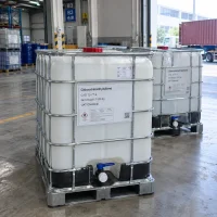 chlorotrimethylsilane-tmcs-cas-75-77-4-1000kg-ibc-tanks-loading IBC tanks labeled Chlorotrimethylsilane CAS 75-77-4 with 1000 kg net weight and flammable symbol at a warehouse loading area with a container truck behind.