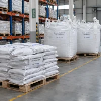 Stacked 25kg bags and large FIBC bulk bags of Chromium(III) Chloride CAS 10025-73-7 on wooden pallets in a finished goods warehouse area.
