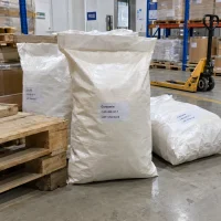 Large white woven bags of Curcumin CAS 458-37-7 on the warehouse floor near a wooden pallet and a manual pallet jack.