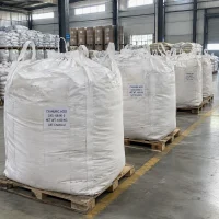 Row of white FIBC bulk bags labeled Cyanuric Acid CAS 108-80-5 with 1000 kg net weight on wooden pallets in a warehouse.