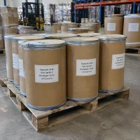 Several 25kg brown fiber drums of Cyanuric Acid CAS 108-80-5 on a wooden pallet in a warehouse with a forklift behind.