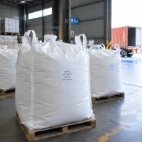 Large white FIBC bags labeled Glycine CAS 56-40-6 1000 kg on wooden pallets near a loading dock.