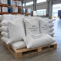 Stacked white woven bags of MCA Melamine Cyanurate CAS 37640-57-6 on a wooden pallet in a warehouse.