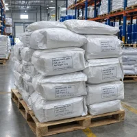 Stacked 25kg white woven bags of Nitrilotriacetic Acid CAS 139-13-9 on a wooden pallet in a warehouse with racks and blue drums in the background.