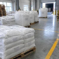 Sodium chloride CAS 7647-14-5 in ton bags and shrink-wrapped bag pallets near loading dock with container