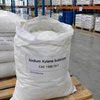 Sodium xylene sulfonate (SXS, CAS 1300-72-7) white crystals in an open woven bag with plastic liner, close-up view