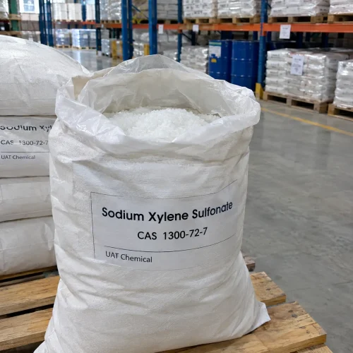 Sodium xylene sulfonate (SXS, CAS 1300-72-7) white crystals in an open woven bag with plastic liner, close-up view