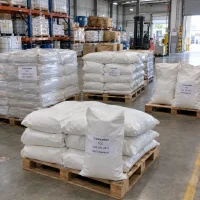 Triclocarban (TCC, CAS 101-20-2) powder in white woven bags stacked on pallets, some shrink-wrapped, in warehouse